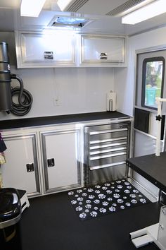 a kitchen with white cabinets and black counter tops, along with an area rug on the floor