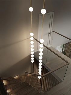 an overhead view of a stair case with lights hanging from it's sides and on the railing