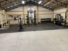 an empty gym with equipment in the middle and no one around it on the other side