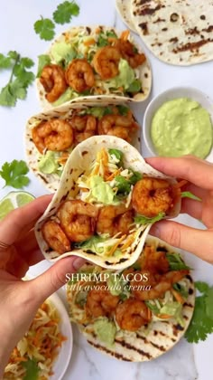 shrimp tacos with guacamole and avocado sauce on the side