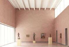 an empty room with statues and paintings on the walls