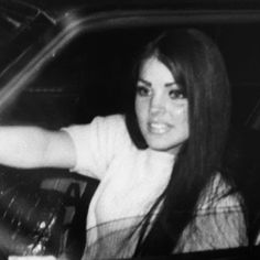 black and white photograph of a woman sitting in a car