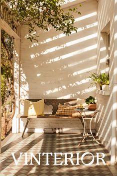 a bench sitting under a tree on top of a tiled floor