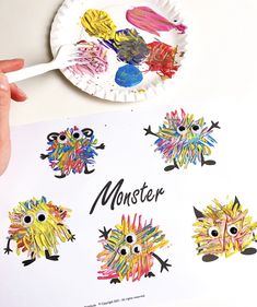 a paper plate with monster pictures on it and a child's hand holding a paintbrush