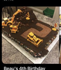 a birthday cake made to look like a construction site with dump trucks and tractors on it