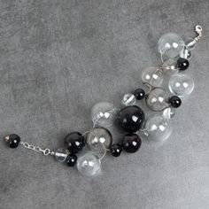 This Black and Clear statement bracelet can be a bright addition to your outfit or simply a unique note, matching your mood and individuality! This bracelet fits a 16-17.5cm diameter wrist. If you need bigger or smaller size bracelet, please, write me the diameter of your wrist when making an order. Dimentions: 21cm. Materials: artist lampwork beads, metal fittings. Colors used: clear, transparent, black. Please, note, each lampwork bead is made by hand and may differ slightly. All the photos th Black Glass Round Bead Jewelry, Black Glass Round Beads Jewelry, Black Glass Jewelry For Jewelry Making, Black Glass Beaded Jewelry, Black Round Glass Jewelry, Modern Black Beaded Bracelet, Glass Bracelet Jewelry For Party, Elegant Silver Glass Bracelets, Elegant Silver Bracelet With Glass