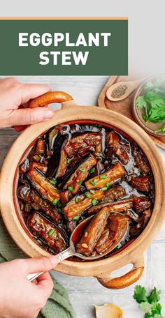 an eggplant stew in a wooden bowl with two hands holding a spoon over it