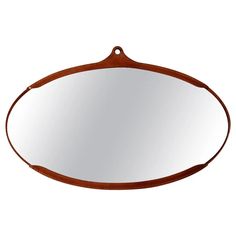 an oval mirror hanging on the wall with a leather strap around it's edge