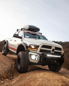 a white truck driving down a dirt road