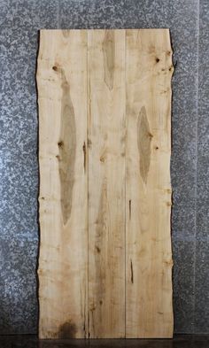 a piece of wood sitting on top of a wooden floor next to a gray wall