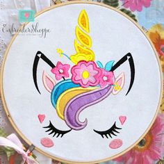 an embroidery project with a unicorn's face and flowers on it