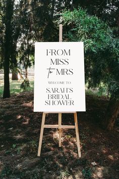 a sign that says from miss to mrs on it in front of some trees and grass