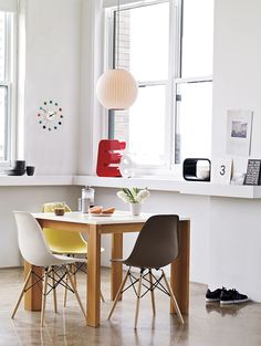 a table with two chairs next to a window in a white walled dining room area