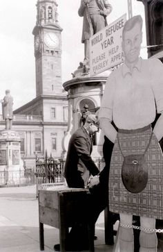 two men standing next to each other in front of a clock tower