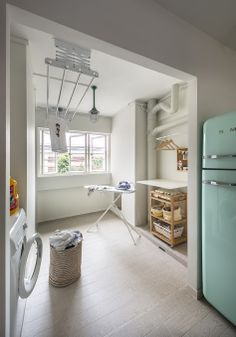 an old fashioned refrigerator is in the middle of a room with white walls and wood floors