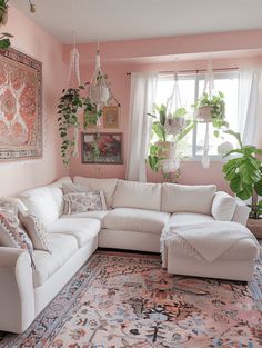 a living room with pink walls and rugs on the floor in front of a large window