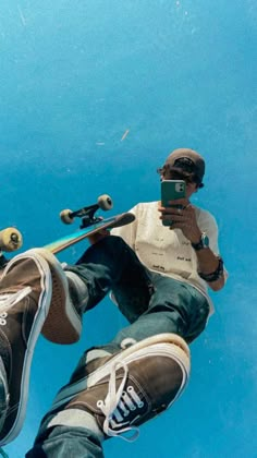 a skateboarder in mid air doing a trick with his board on the ground