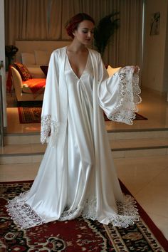 Cut off to receive in time for Christmas has passed. Any orders placed as of 11/26 are not guaranteed for Christmas delivery. Turnaround time is 4 weeks to ship from date ordered. The Isadora robe is a decadent rich off white pearl satin accented with beautiful crocheted Venise lace around the hem and wide angel sleeves. Shimmering satin glows on the outside and is just as delicious on the inside next to the skin for the utmost in luxury. It comes with a tie sash belt. Perfect for the bride who Wedding Nightgown, Wedding Sleepwear, Bridal Robe Lace, Satin Bridal Robe, Bridal Sleepwear, Bridal Nightwear, Bridal Nightgown, Wedding Night Lingerie, Lace Bridal Robe