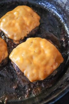 three hamburger patties cooking in a skillet