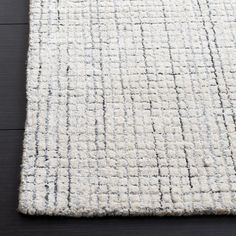 a white rug on top of a wooden floor