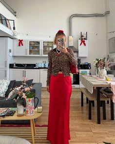 a woman is taking a selfie in her living room while wearing a red skirt