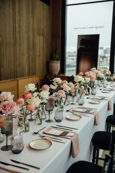 a long table is set with flowers and place settings