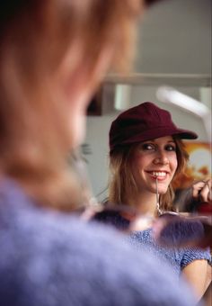 a woman is looking at her reflection in the mirror