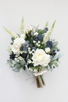 a bouquet of white and blue flowers with greenery