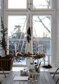 a dining room table is set with candles and place settings in front of an open window