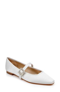 a woman's white flat shoe with a bow on the front and heel,