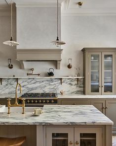 a kitchen with marble counter tops and gold faucets