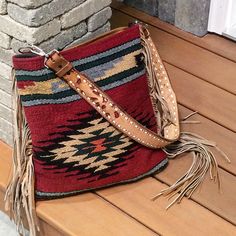 a red purse sitting on top of a wooden bench