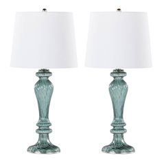 pair of green glass lamps with white shades on each lamp and the base is turned off