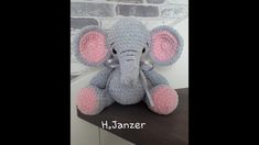 an elephant stuffed animal sitting on top of a shelf