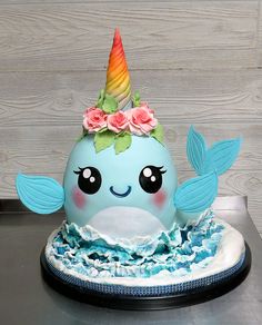 a cake shaped like a narwhale with flowers on it's head