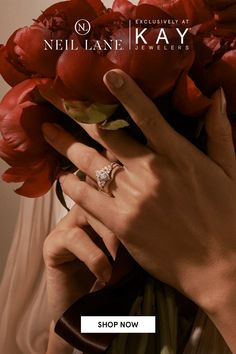 a woman's hand holding a bouquet of red flowers with the words nel lane jewellers on it