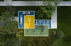 an aerial view of two people playing tennis on a court in the middle of a park