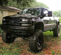 a large black truck parked in the grass