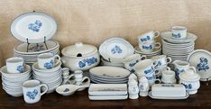 a table topped with lots of white and blue dishes