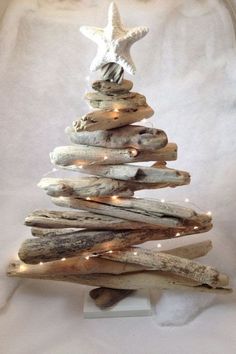 a christmas tree made out of driftwood with lights on the bottom and a starfish