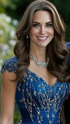 a woman in a blue dress smiling at the camera