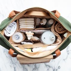 the inside of a purse with all its contents in it on a marble countertop