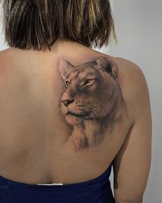 a woman with a lion tattoo on her back