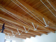 the ceiling is covered with wooden planks and white wires hanging from it's sides