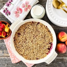 an apple crumbler pie with fresh fruit and milk on the side next to it