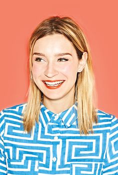 a woman with blonde hair wearing a blue and white striped shirt smiling at the camera