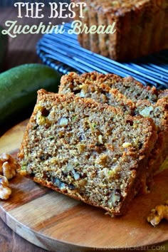 two slices of zucchini bread sitting on top of a wooden cutting board with walnuts