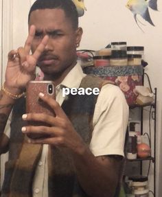 a man taking a selfie with his cell phone in front of him and the words peace written on it