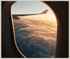 the view out an airplane window shows clouds below