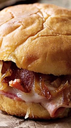 a close up of a sandwich on a piece of wax paper with meat and cheese